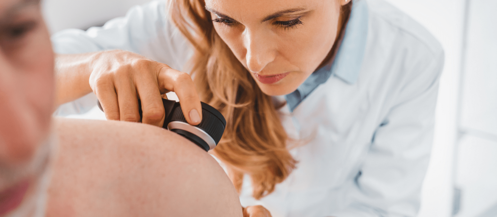 a girl getting her skin checked by the doctor