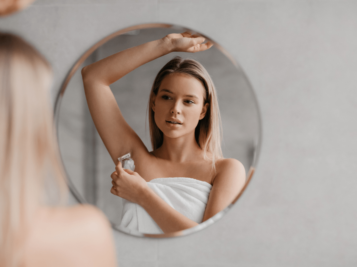 woman looking in the mirror shaving