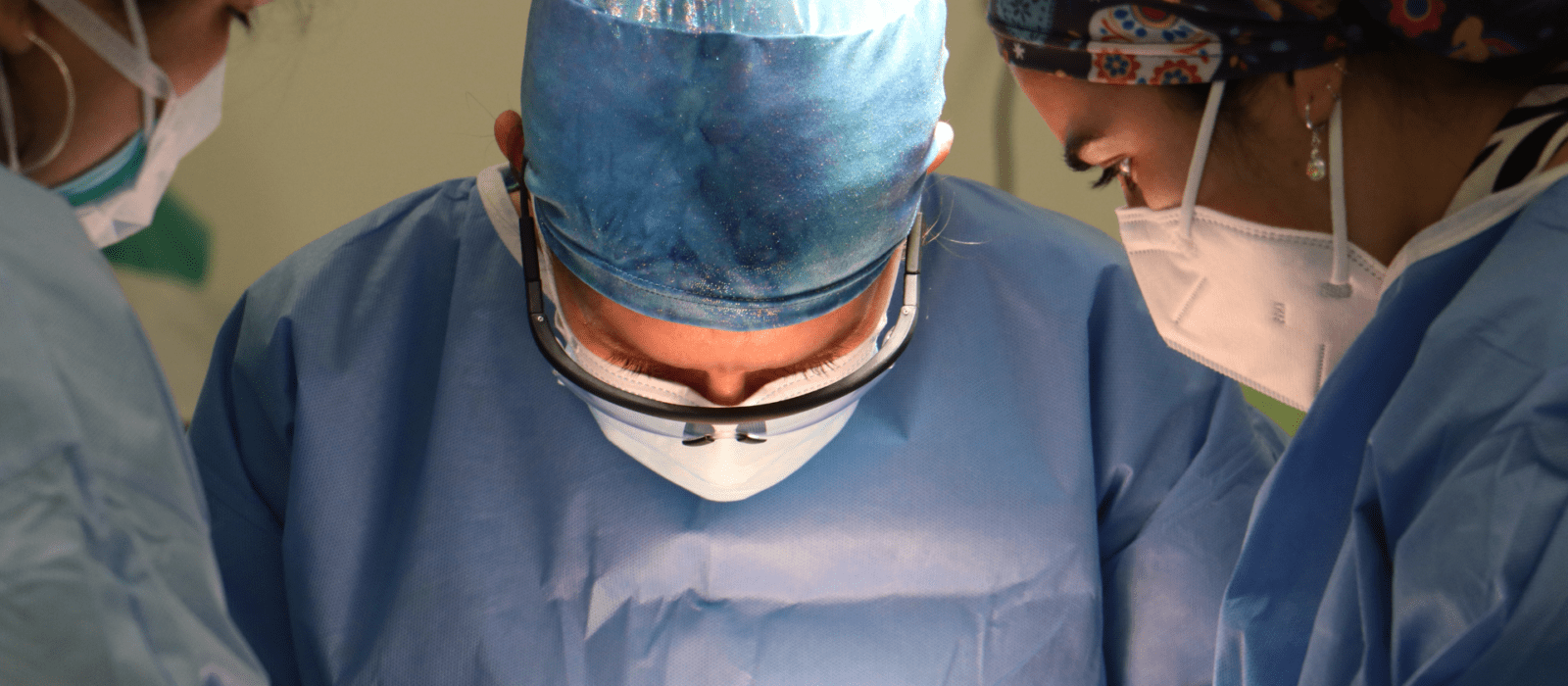 Three surgical dermatologists performing Mohs surgery on a patient.